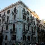 Continuiamo a percorrere via Crisanzio superando l�elegante edificio bianco e crema che si trova sull�angolo opposto, che con i suoi quattro livelli coniuga neoclassicismo e liberty con una geometria pi� severa...